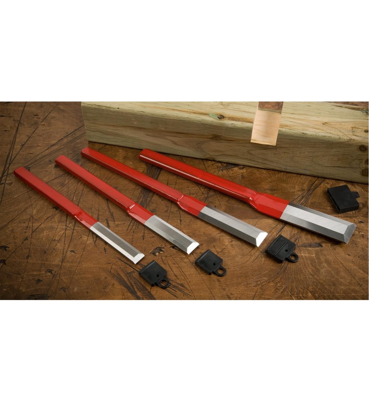 Carpenter's Chisels lying on a table with blade guards and a block of wood