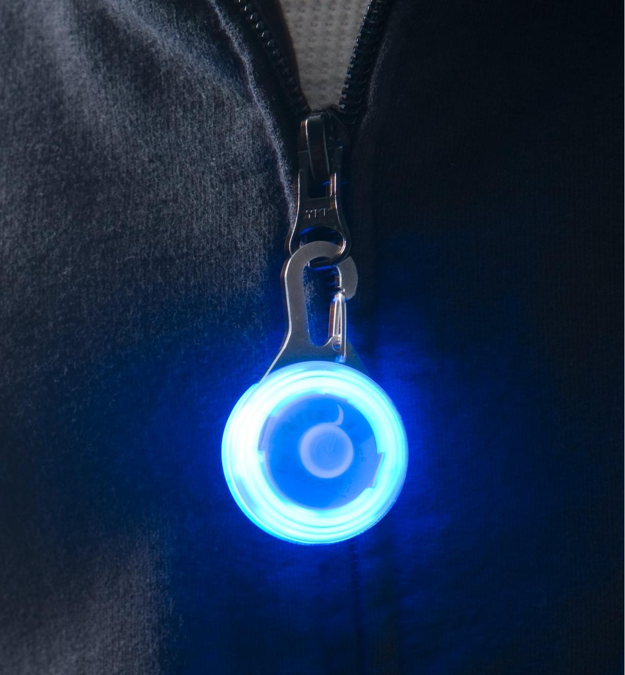 Blue Carabiner Light attached to a sweatshirt zipper