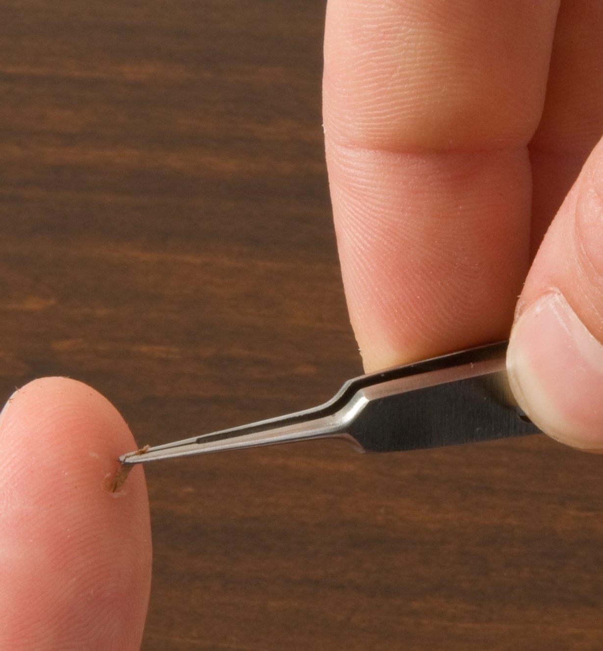 Using Corneal Tweezers to remove a sliver from a finger