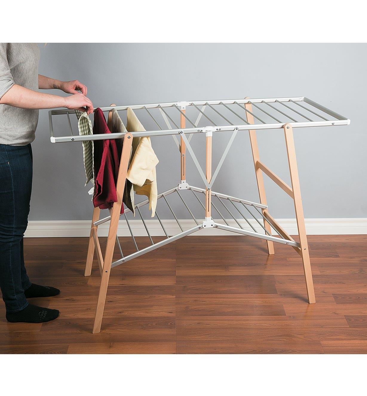 Folding Floor Clothes Dryer unfolded with towels and clothes hanging on the bars