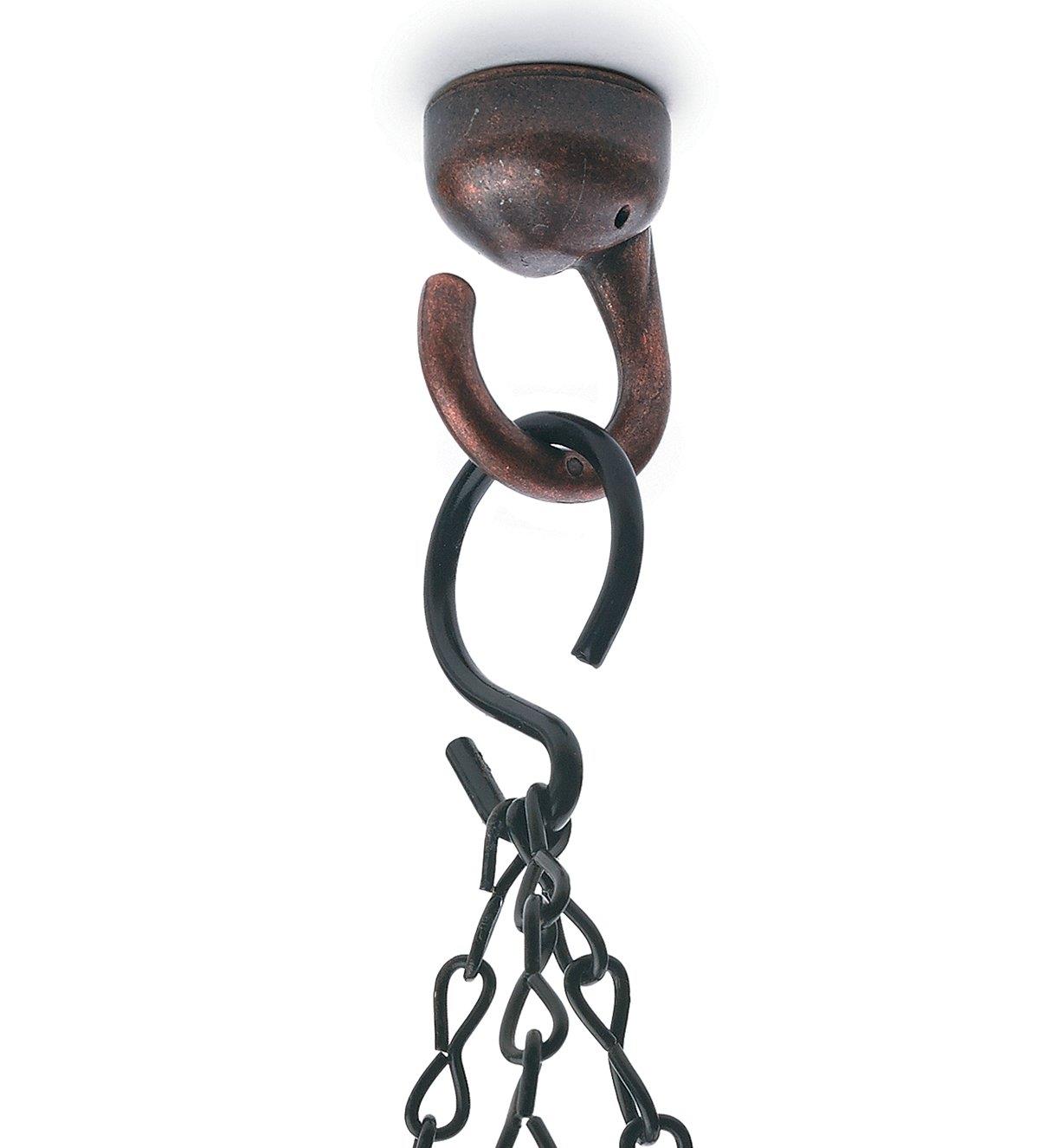 A hook holding three chains hanging from an installed Bronze Elephant Ceiling Hook