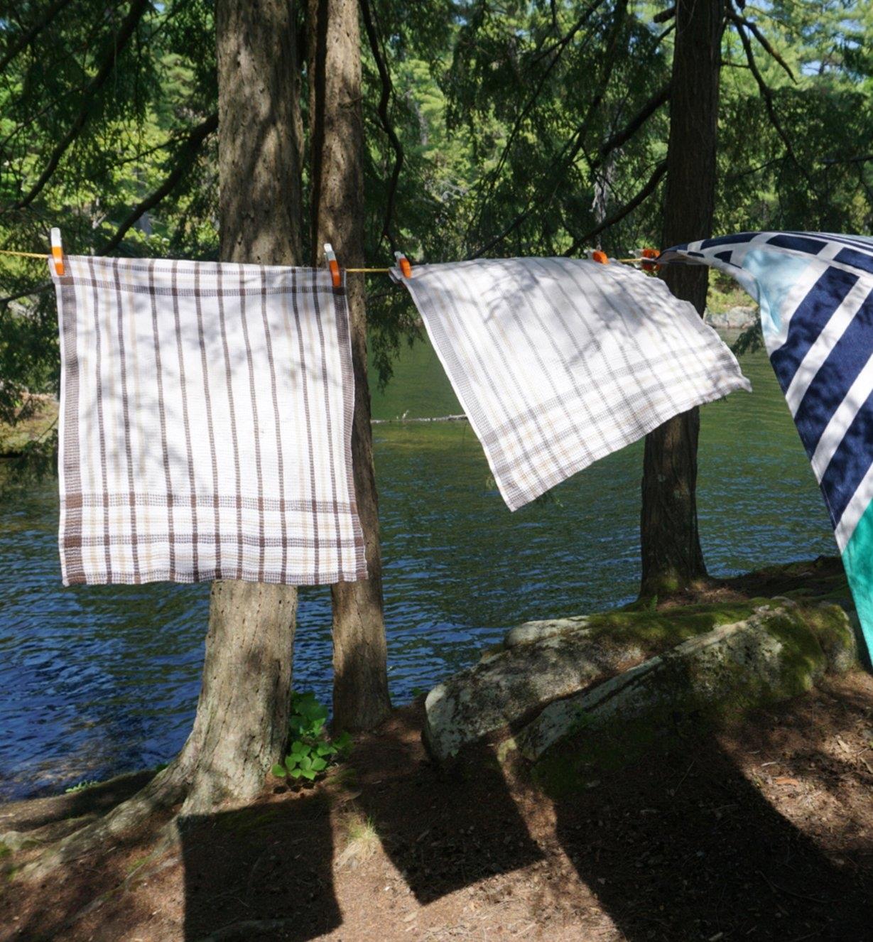 FixClip Clothespins holding towels on a clothesline in the woods by a river