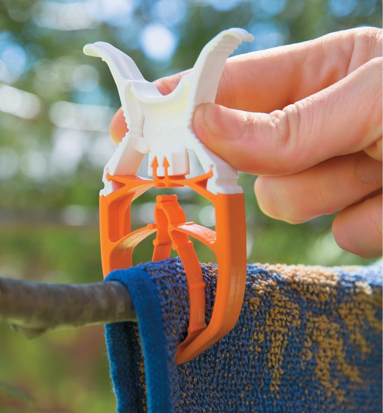 Close-up of FixClip Clothespin clipping onto a towel folded over a tree branch