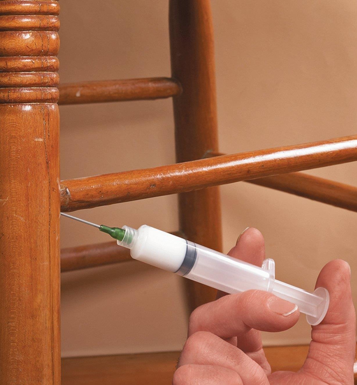 Injecting glue into a chair joint with a syringe