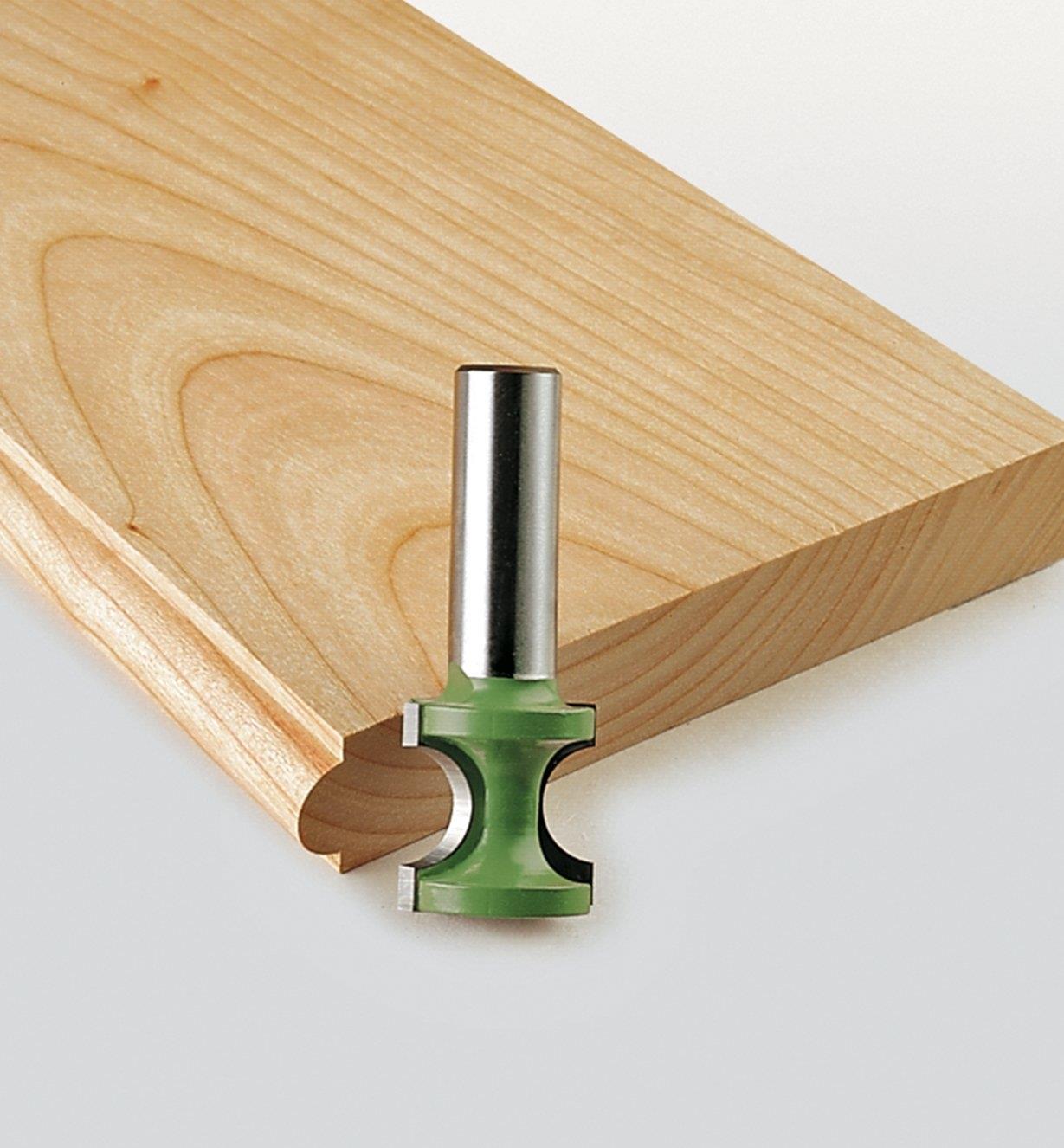 External bull-nose bit next to a board with a profile cut into it