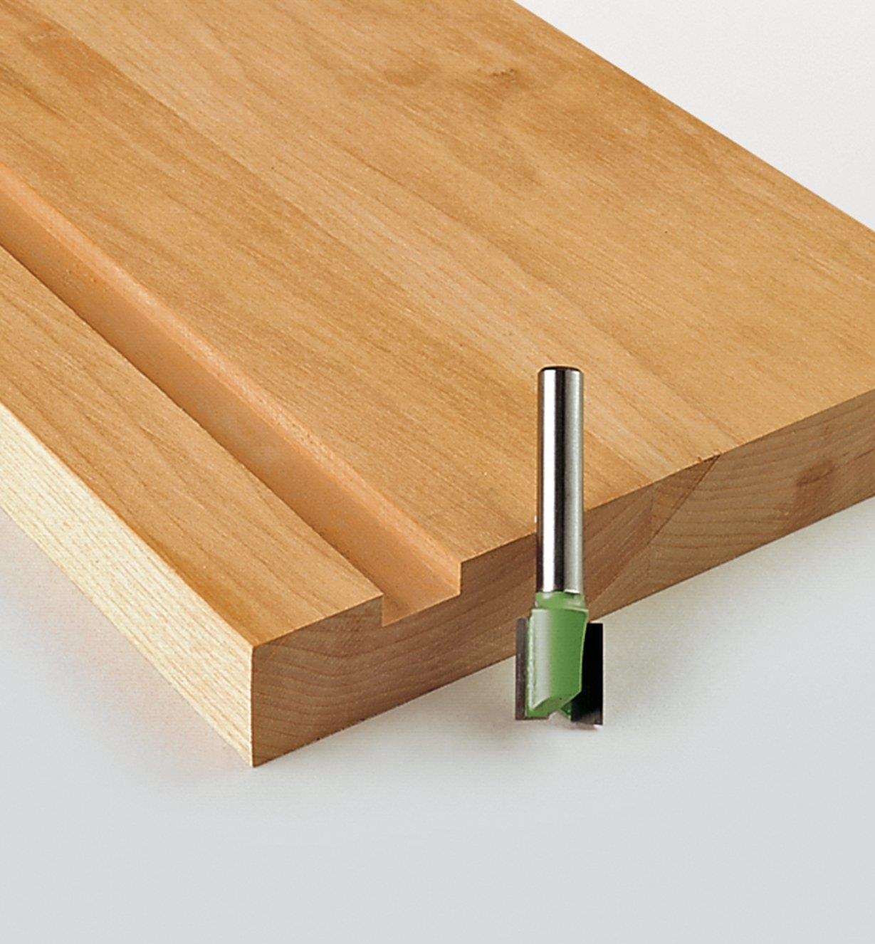 Hinge Mortising Bit next to a board with a groove cut into it