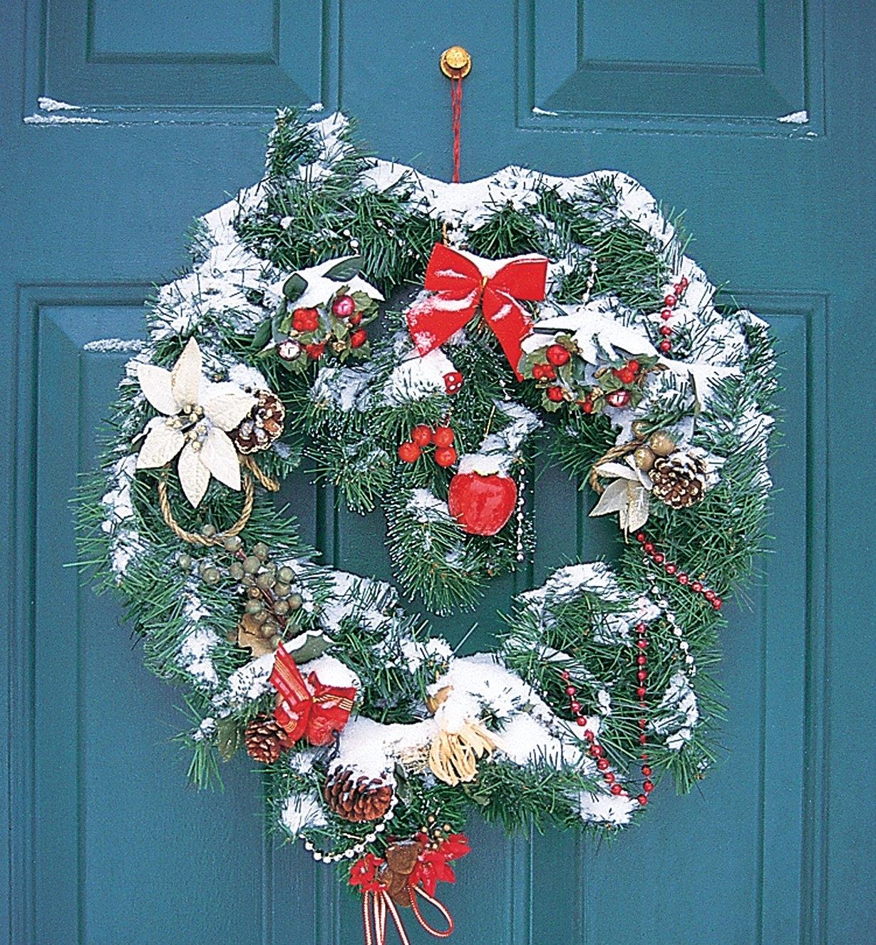 A Hanger Knob holding a Christmas wreath on an exterior door