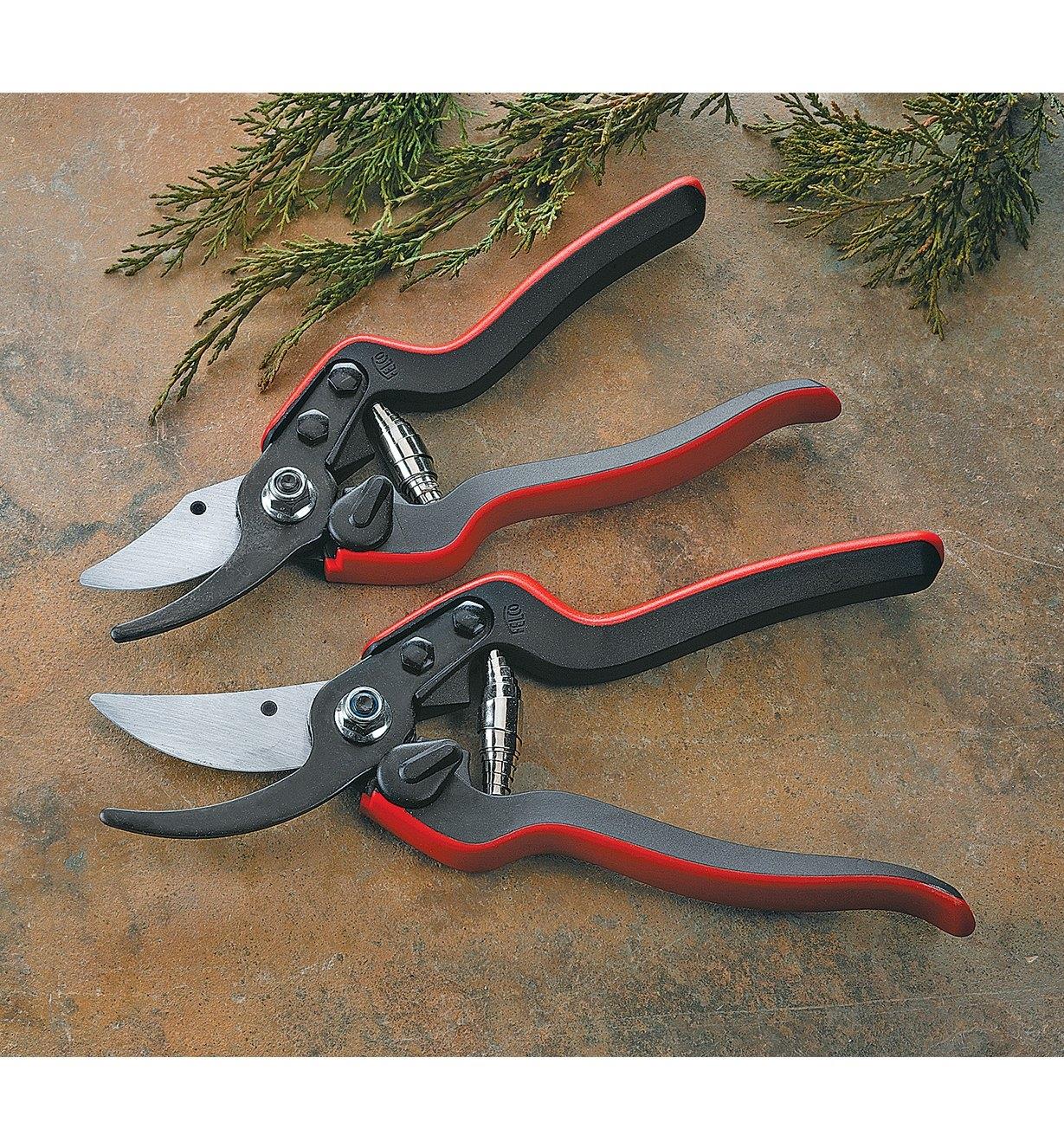 Two Felco Composite-Handle Pruners lying next to some cut branches