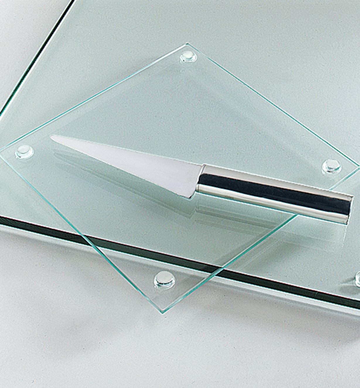 Flat-Bottom Bumpers mounted on the bottom of a glass cutting board sitting on a glass tabletop