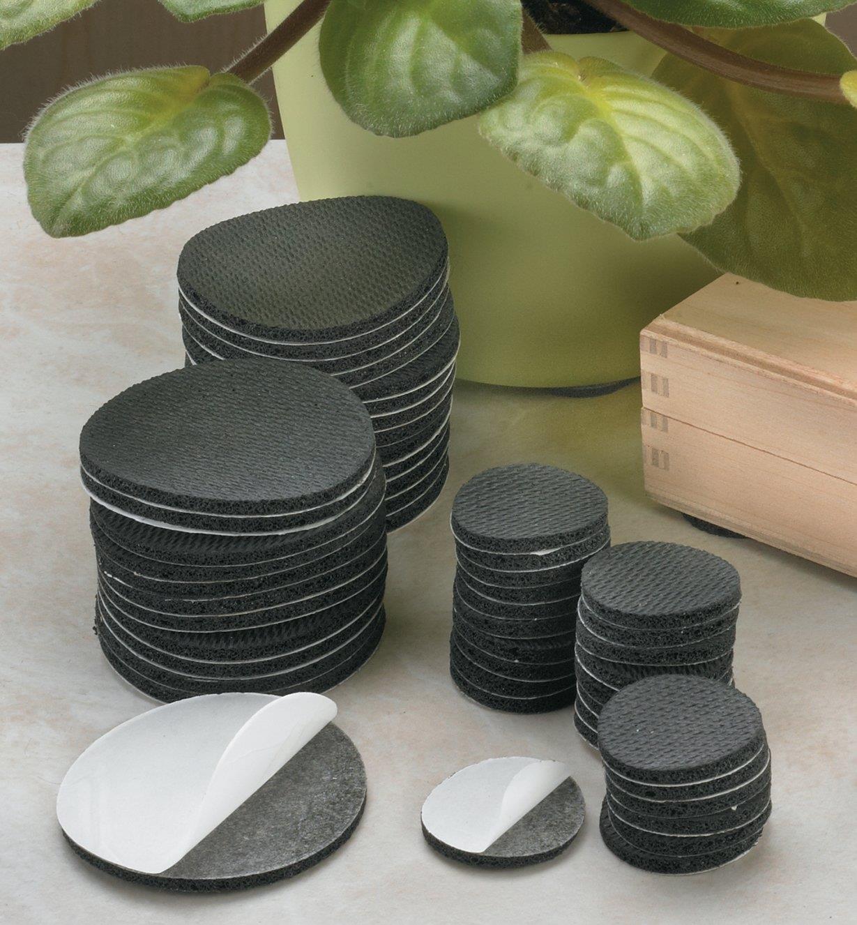 Two sizes of High-Friction Grip Discs piled beside a wooden box and a planter