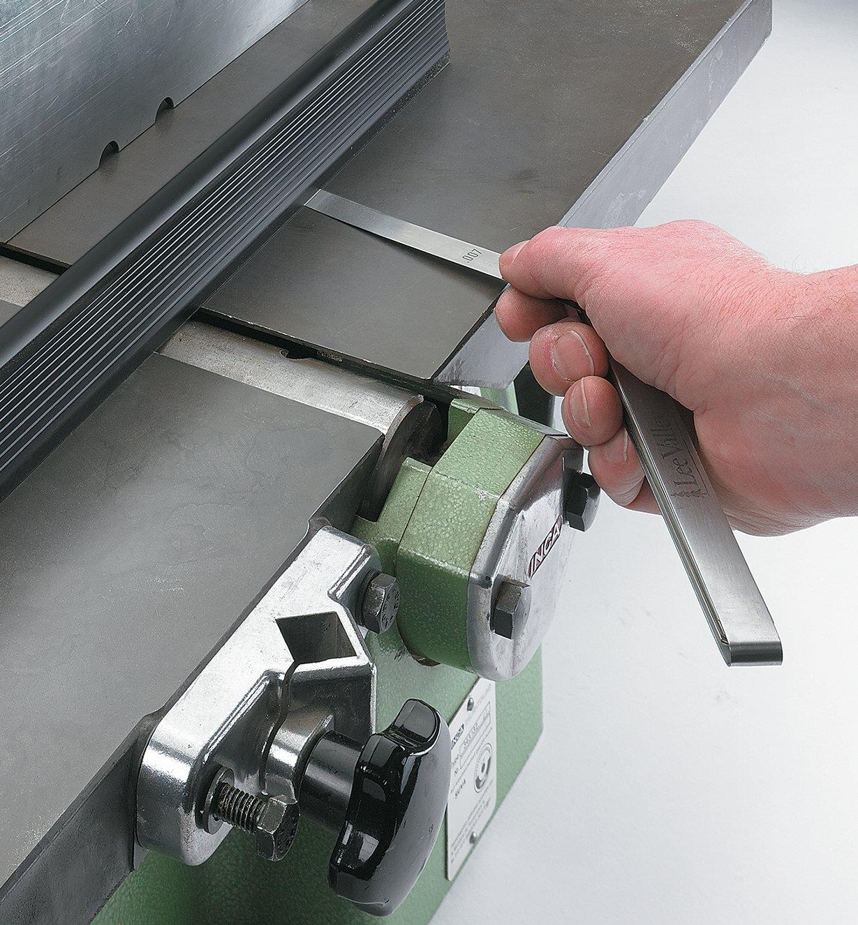 Using feeler gauges to check the infeed and outfeed surfaces are set up correctly on a surface planer