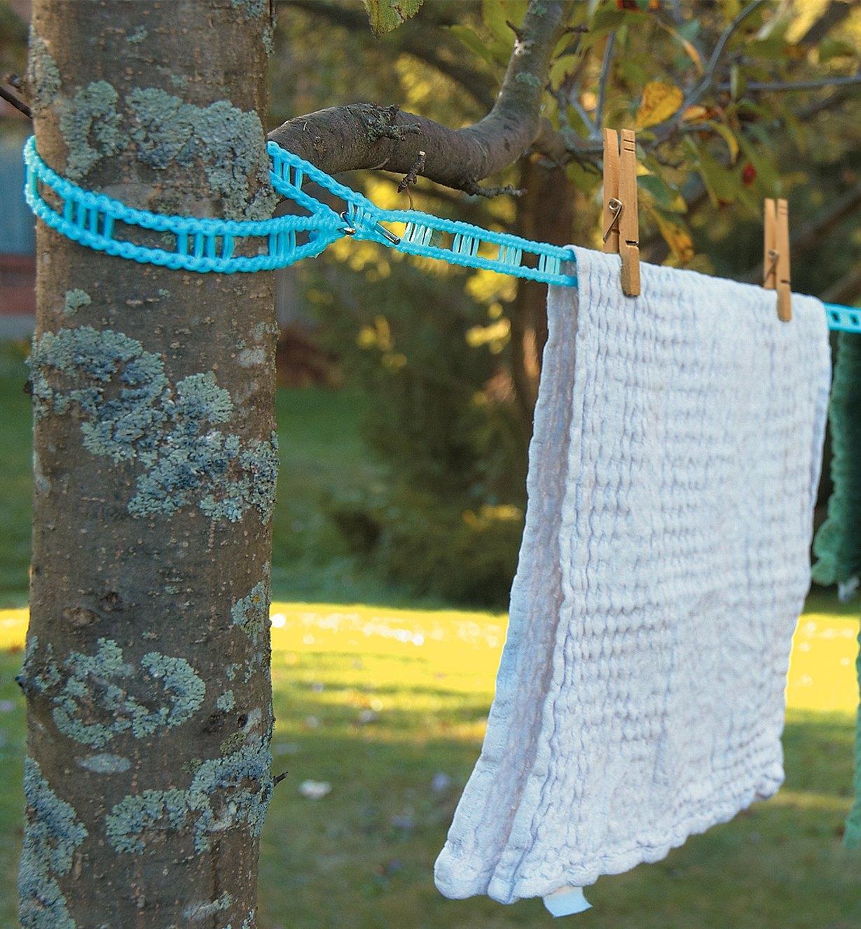 Hook-Anywhere Clothesline attached to a tree with a towel clipped on with clothespins