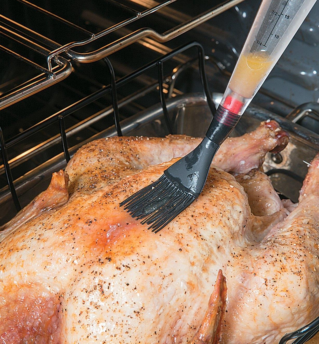 Basting a turkey using the brush attachment on the Dripless Baster