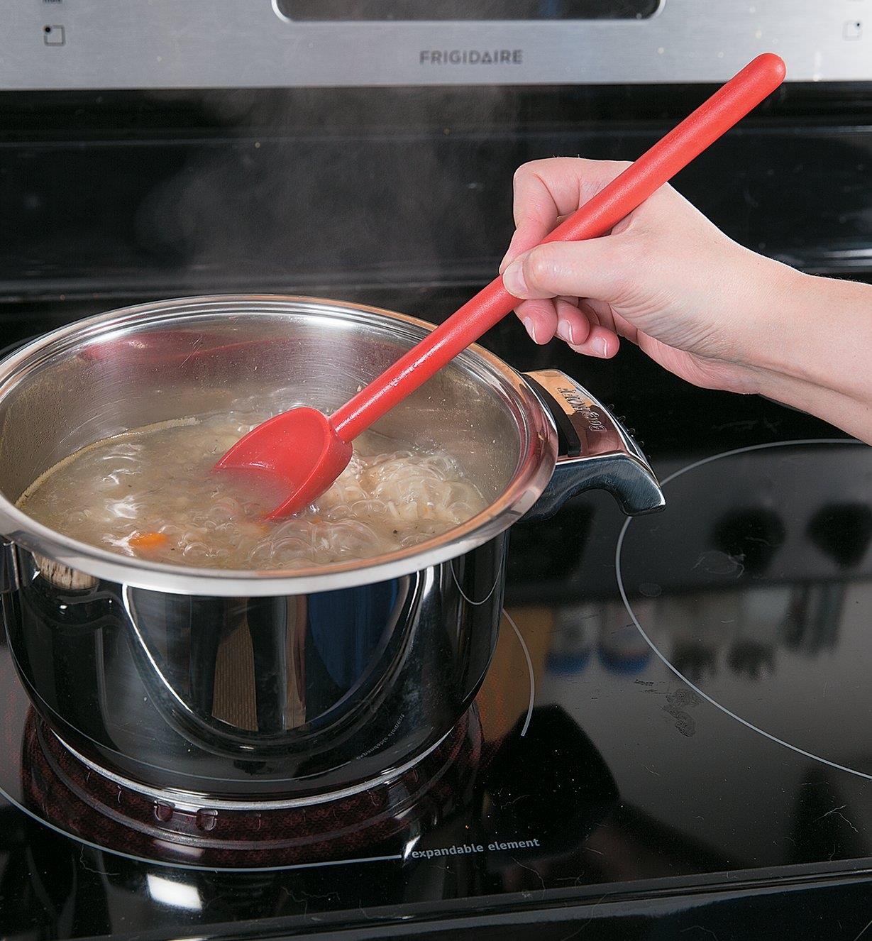Stirring soup on a stovetop with the High-Heat Spoon
