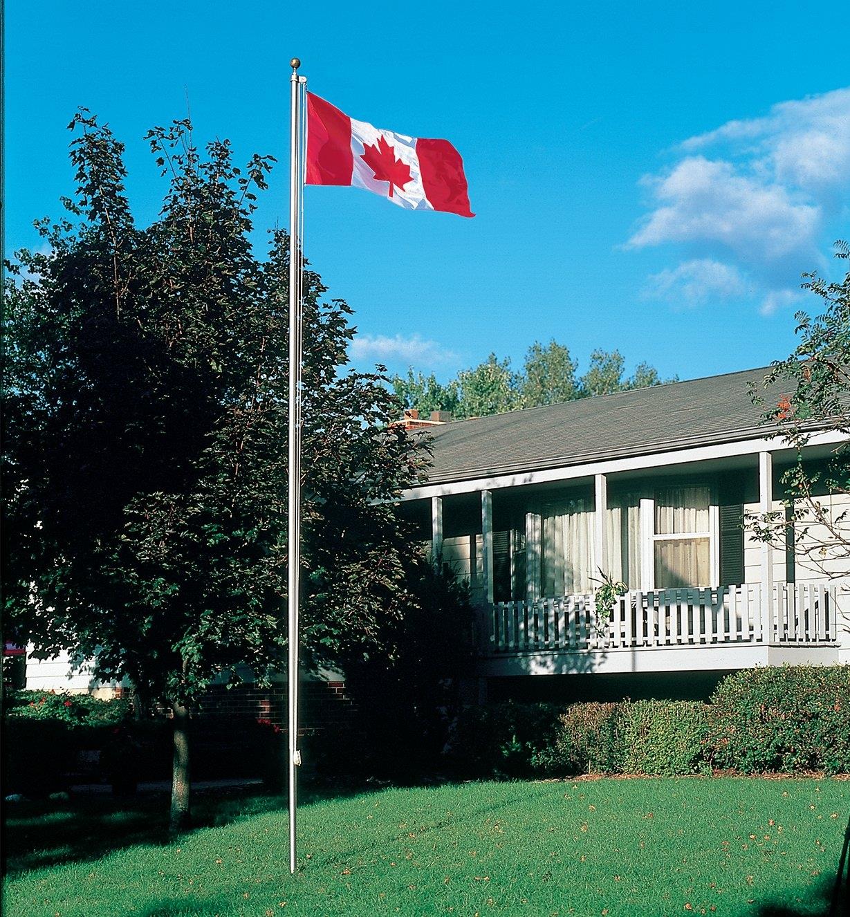 Deluxe Canadian Flag raised on a flagpole in front of a house