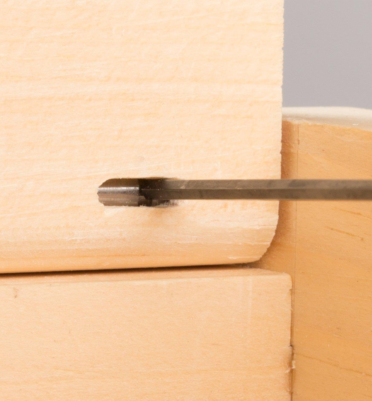 Pushing back the installed hinge pin with a narrow tool through a groove in the lid to remove the box lid