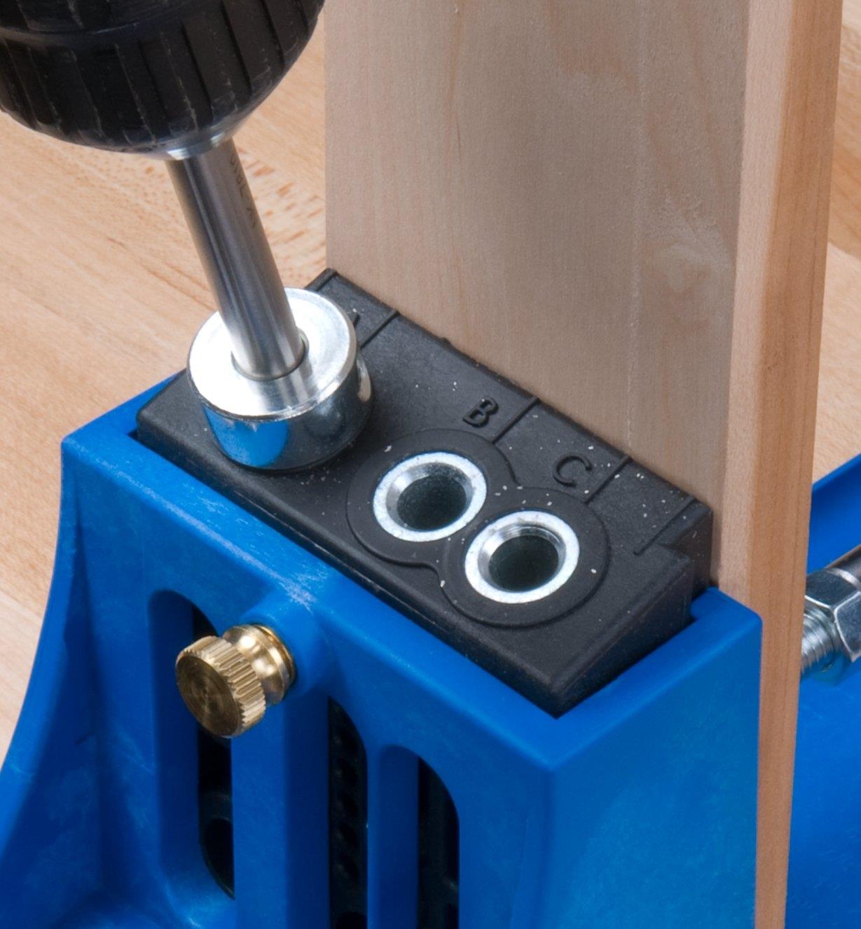 Using the guide to drill a pocket hole in a board
