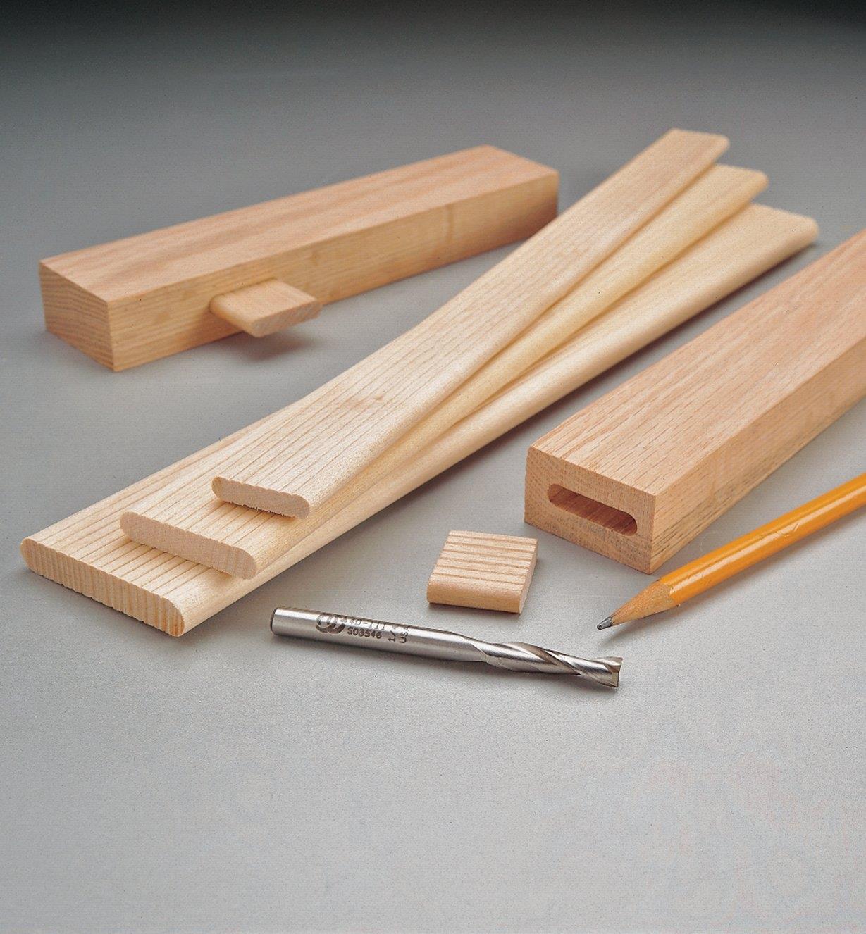 Three sizes of 12" floating tenons sitting next to two tenons cut to size with matching mortises