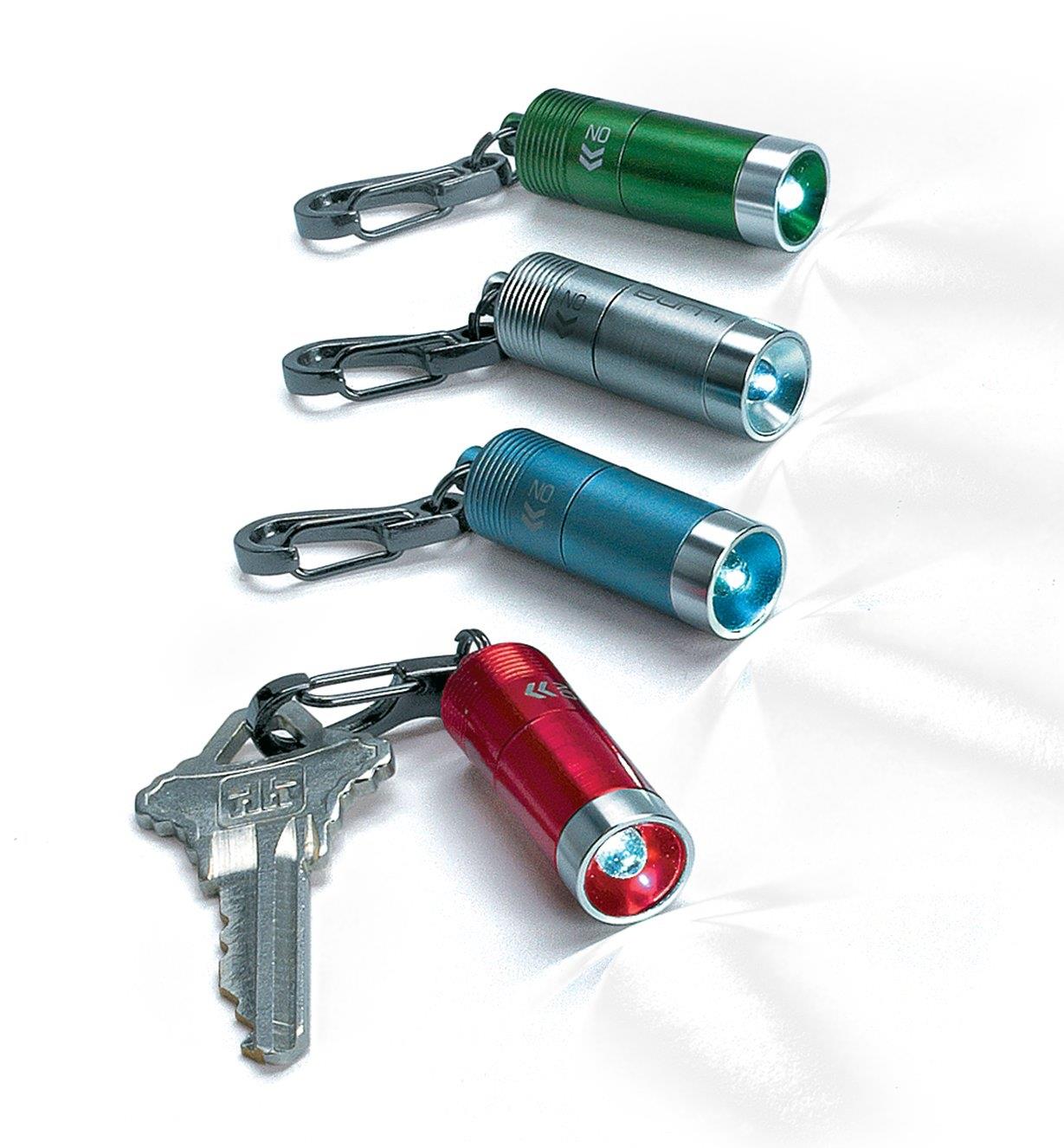 Four mini clip LED lights in different colors, with one attached to a key