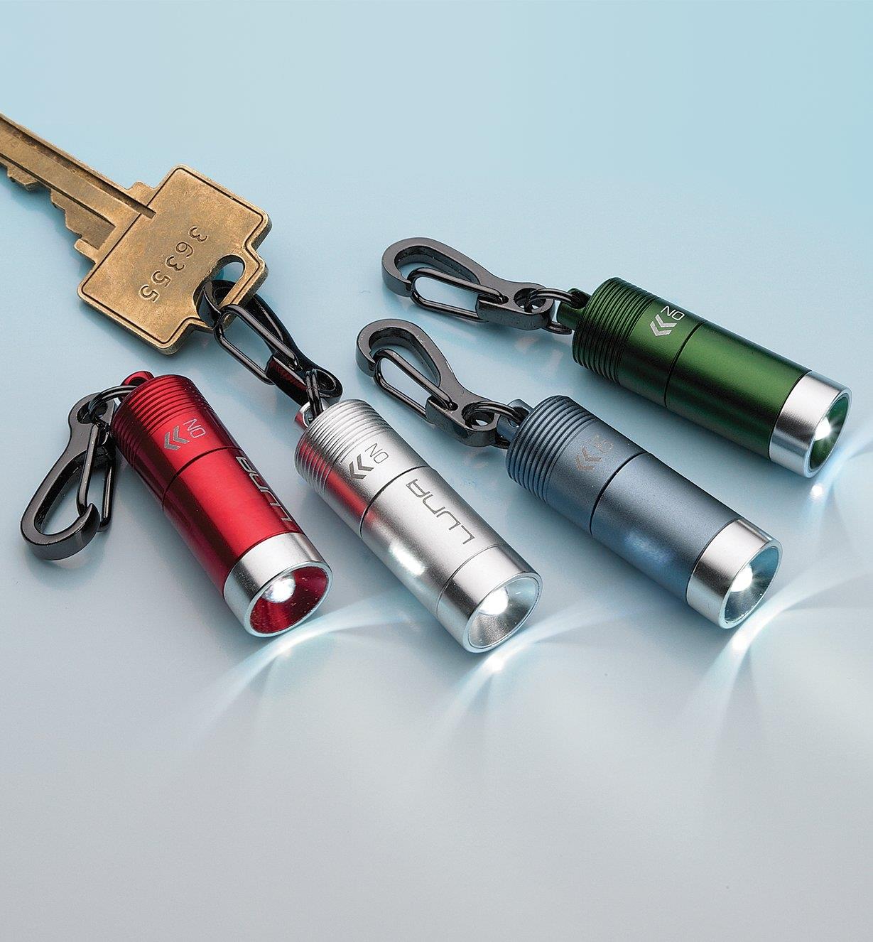 Four mini clip LED lights in different colors, with one attached to a key