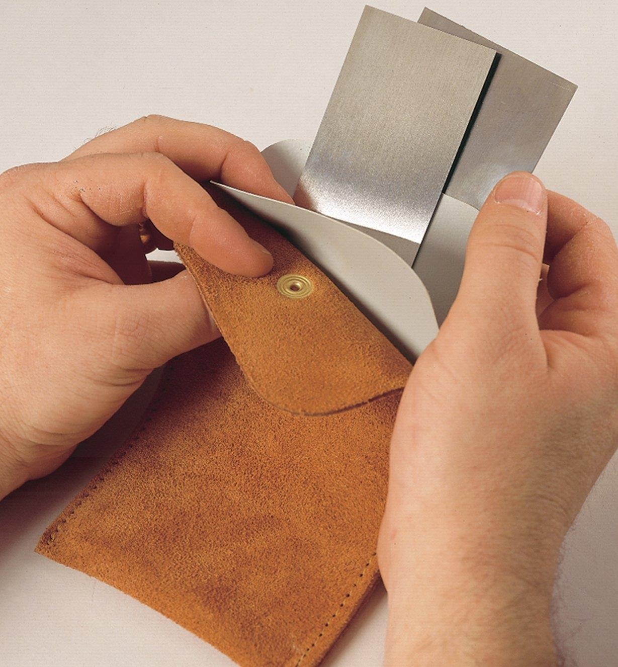 Putting several scrapers into the Leather Scraper Pouch
