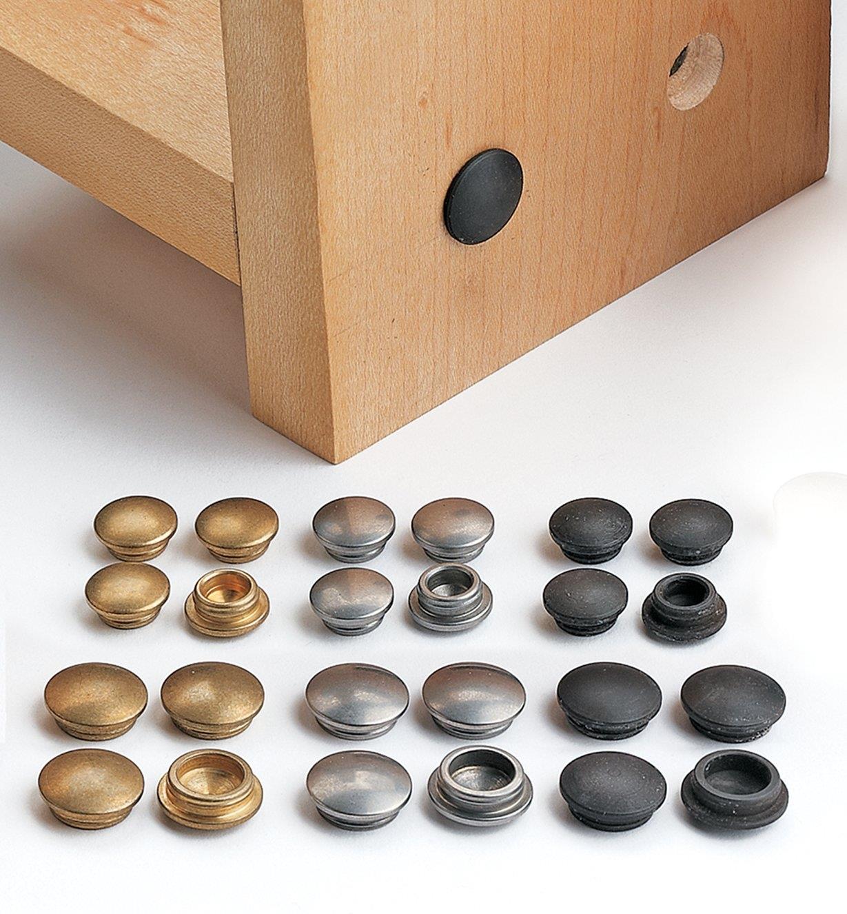 All three finishes of Decorative Hole Plugs arranged in front of a furniture piece with plugs installed