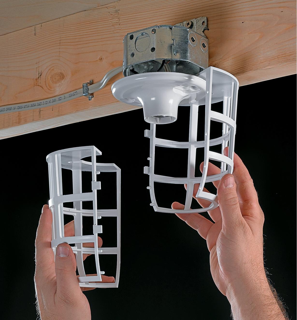 Separating the two halves of the light bulb cage in order to change the lightbulb