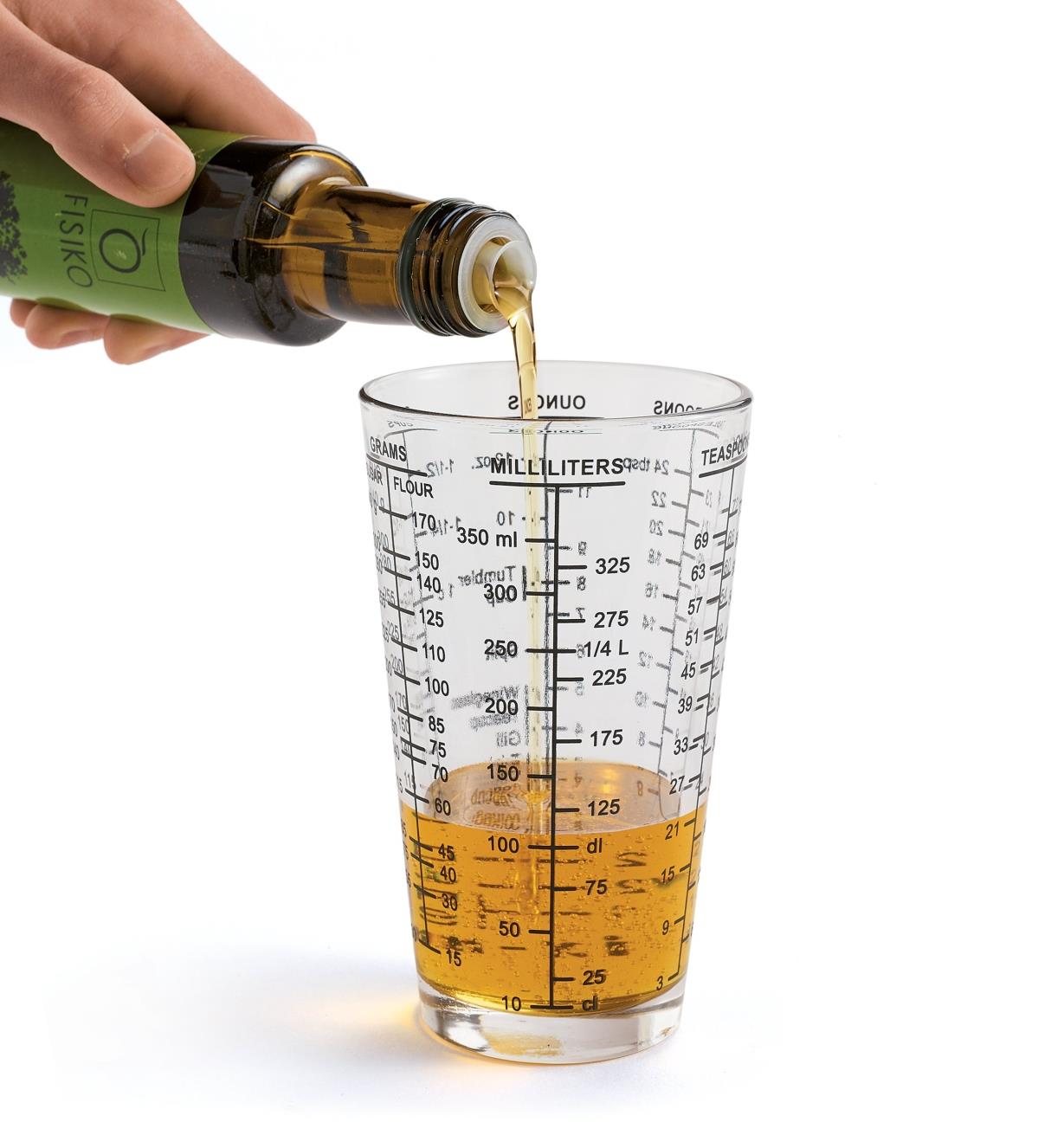 Personne versant de l'huile dans un verre à mesurer