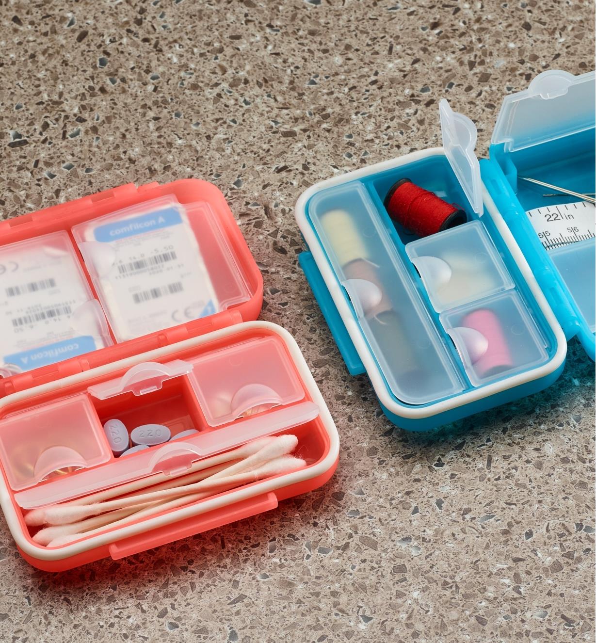 Petite boîte de rangement verrouillable rouge servant de trousse de premiers soins et petite boîte de rangement verrouillable bleue remplie d'accessoires de couture