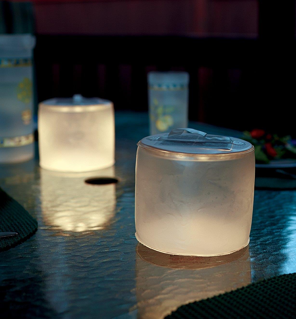 Two frosted Luci lanterns illuminating an outdoor table