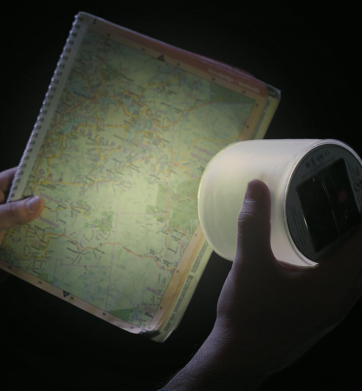 Using the Emergency Luci Lantern to illuminate a map in the dark