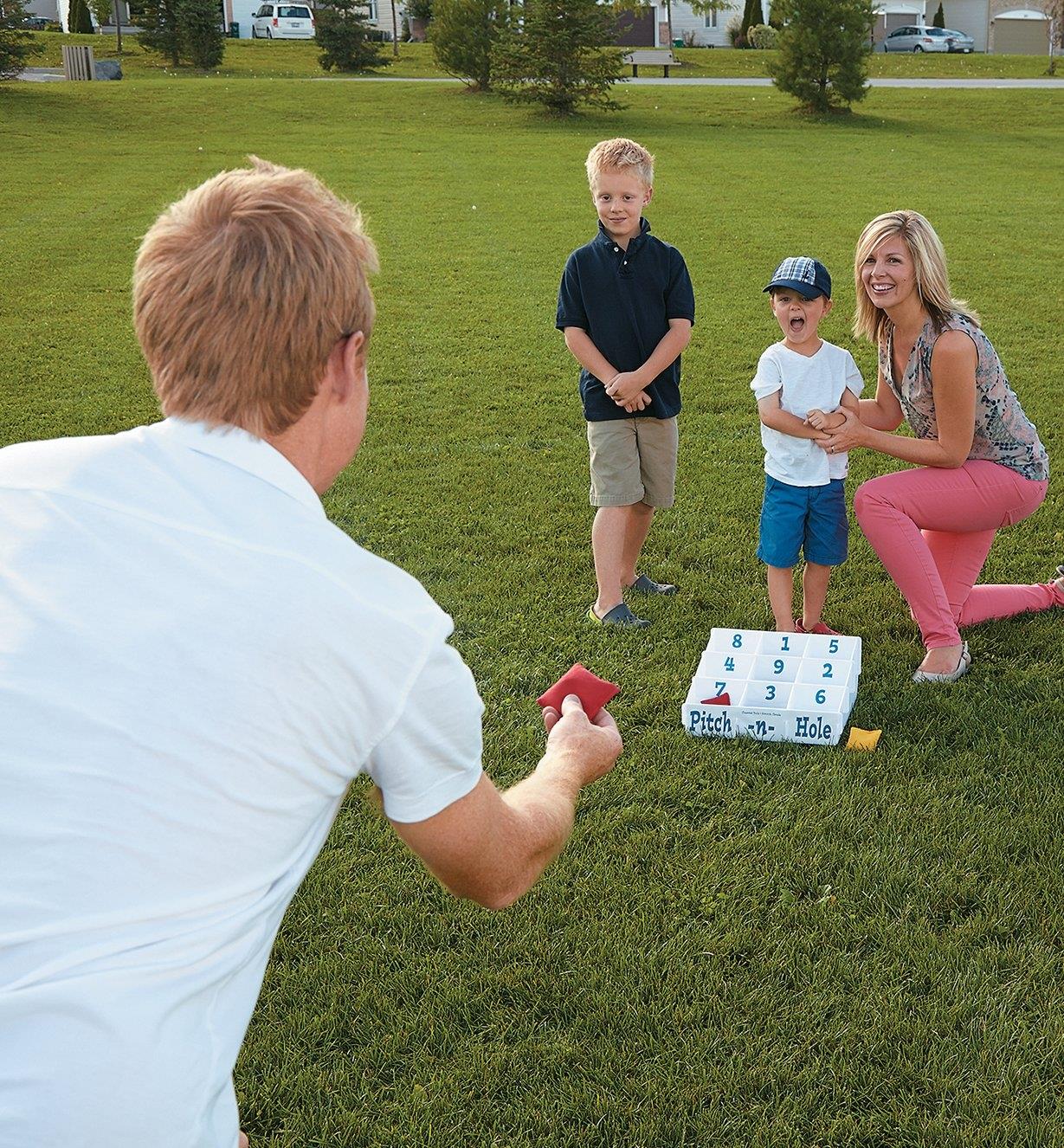 A family plays a game of Pitch-n-Hole at a park