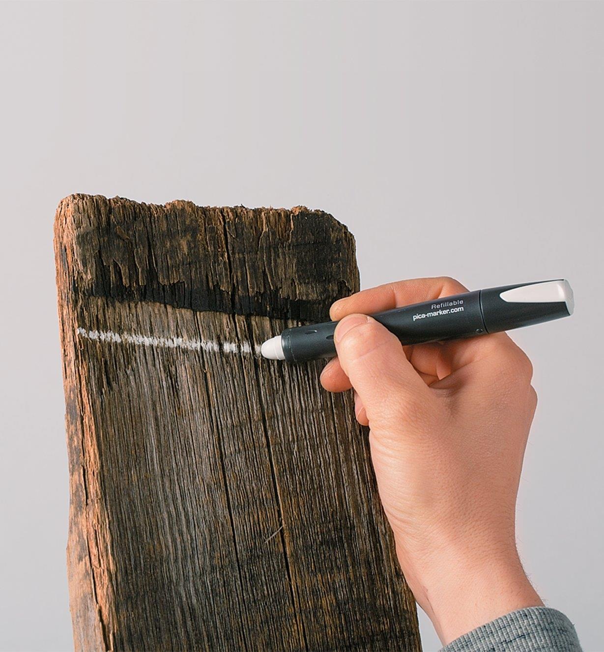 Drawing a line on dark wood with a Pica-Visor White Marking Crayon