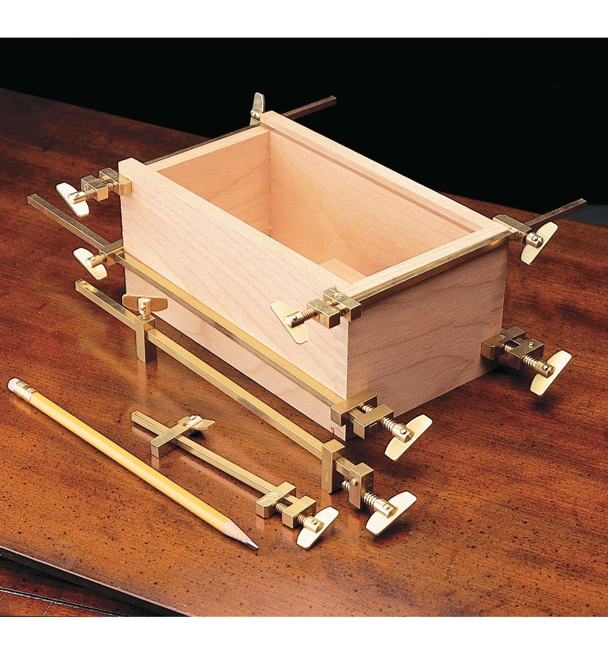 Four Miniature Brass Bar Clamps clamping a small box