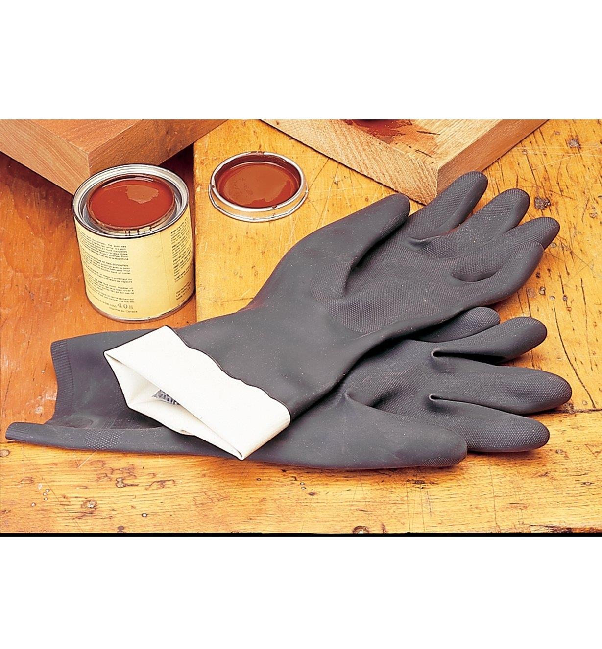 Neoprene Gloves lying next to a can of stain