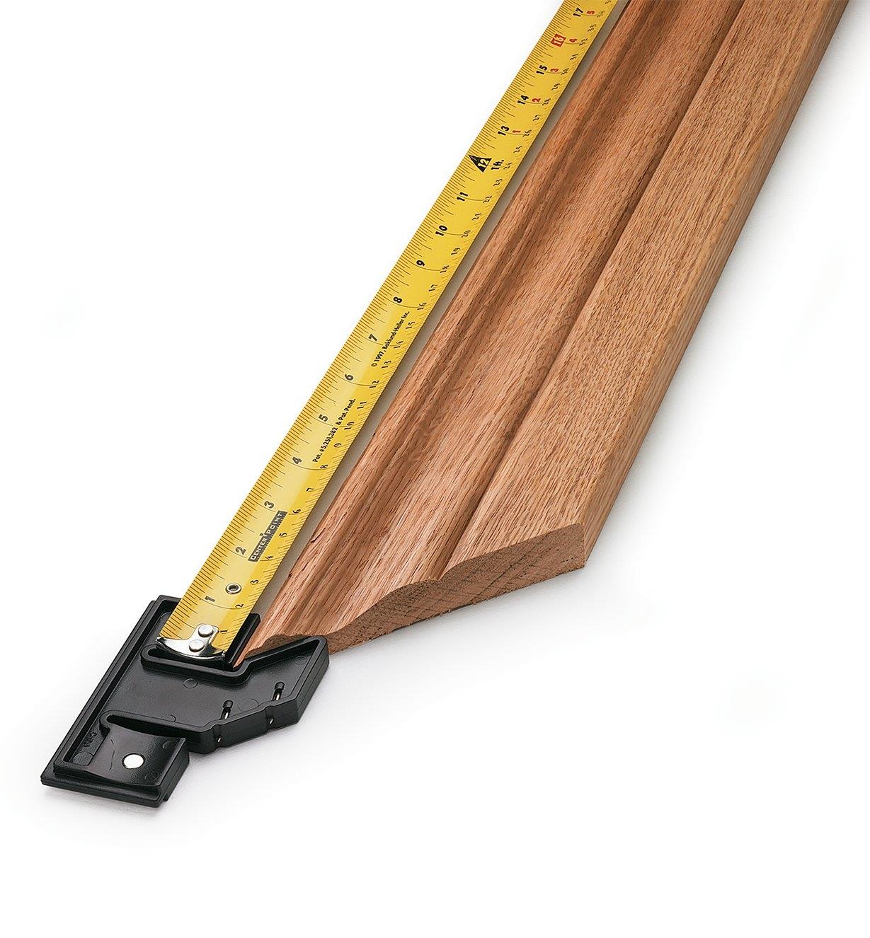 Using a measuring tape and miter hook to measure from the outside corner of molding