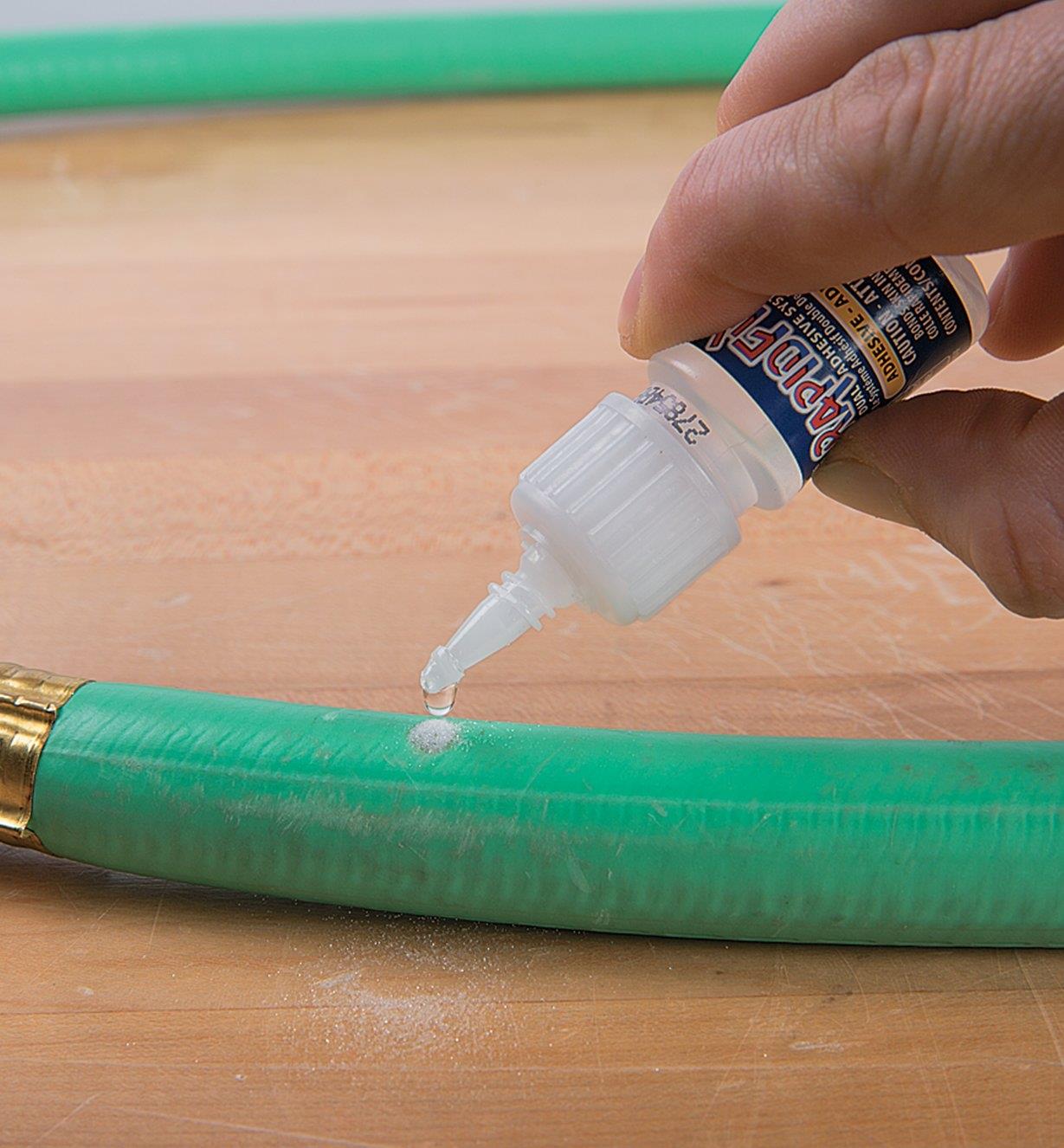 Applying glue over the glue and powder previously applied to the hose