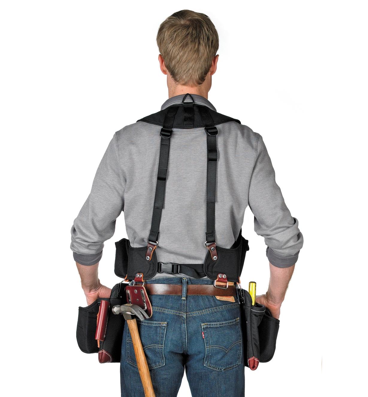 Back view of man wearing builder's vest with clip-on tool bag and fastener bag (sold separately).