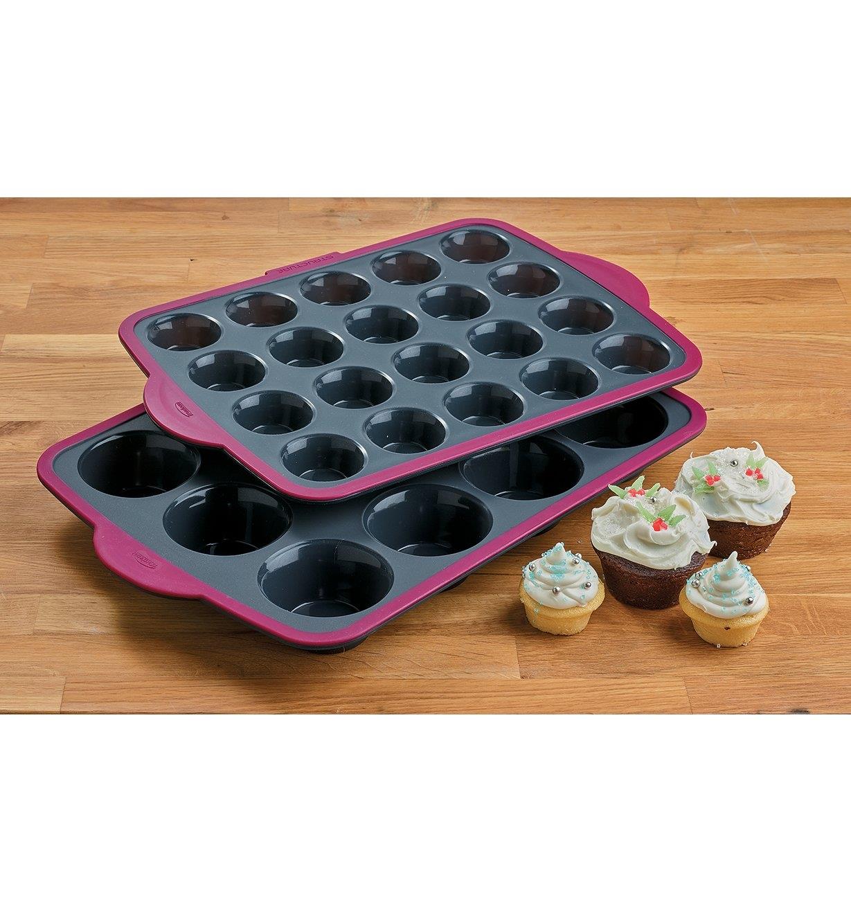 Stacked regular and mini Muffin Pans beside four frosted cupcakes