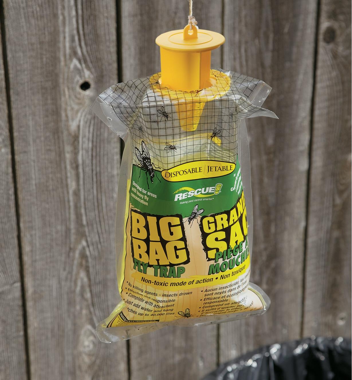 Outdoor Disposable Fly Trap hanging by a fence