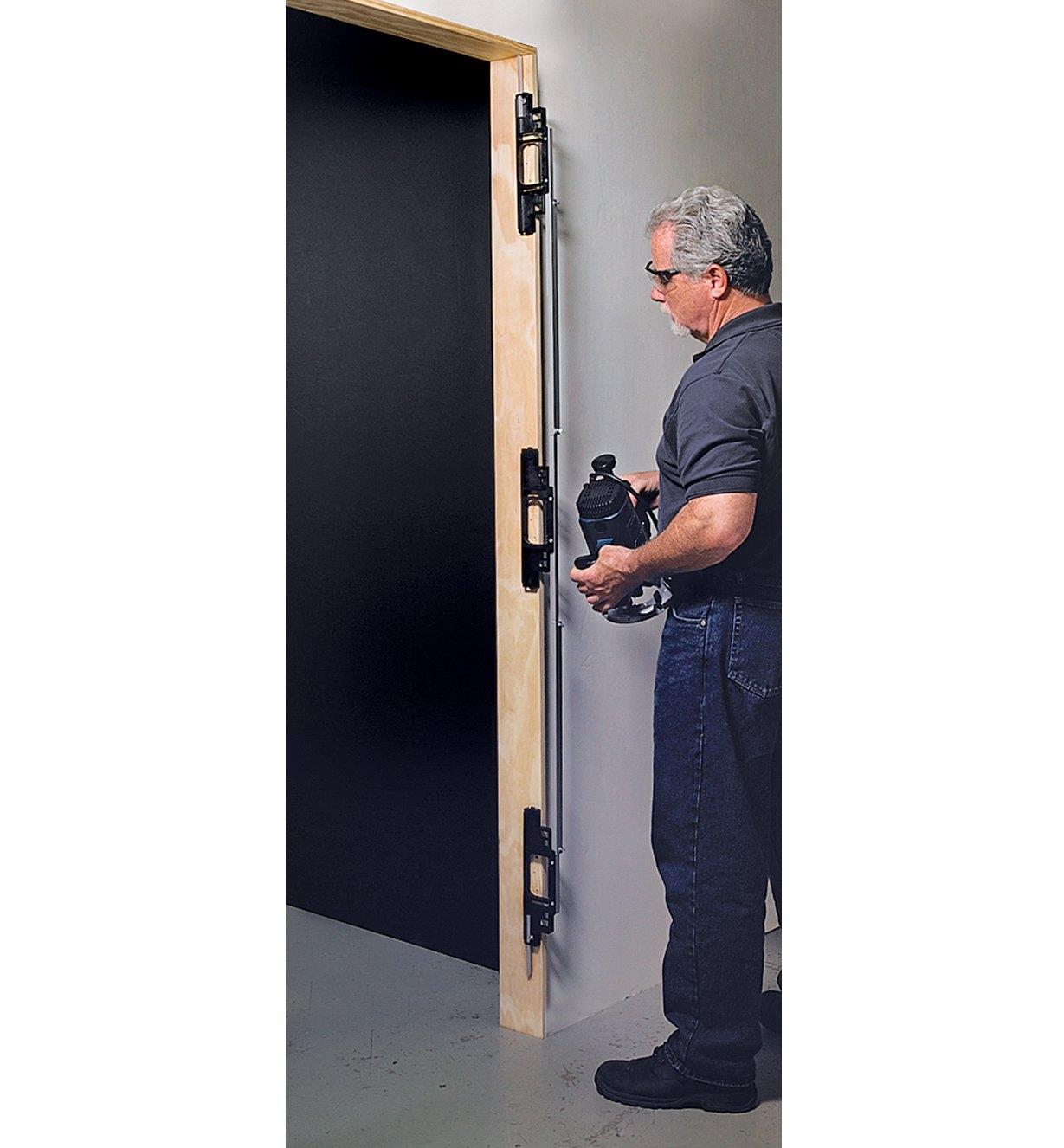A man prepares to rout mortises in a door using the Hinge Mortising System