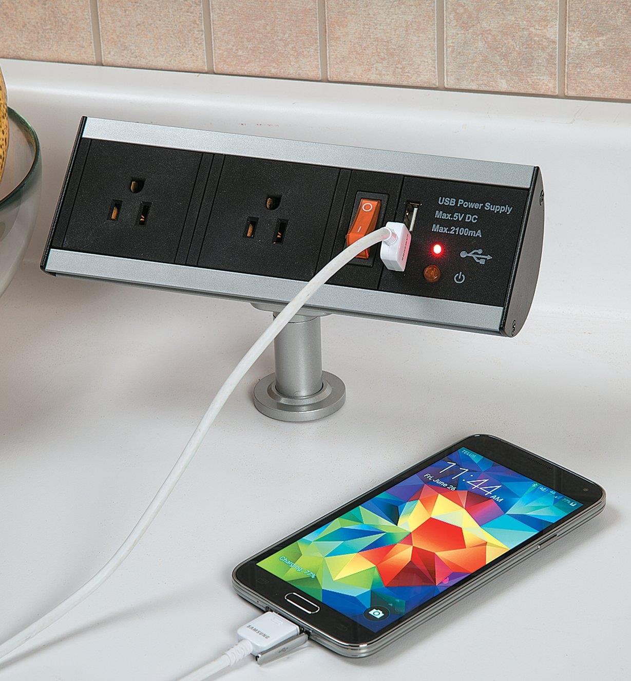 Cell phone plugged into a Stand-Off Power Bar installed in a kitchen counter