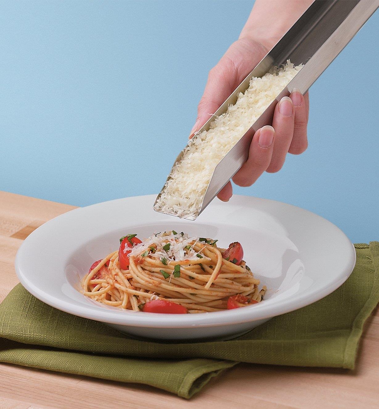 Using the Zester Holder to transfer freshly grated Parmesan cheese to a bowl of pasta