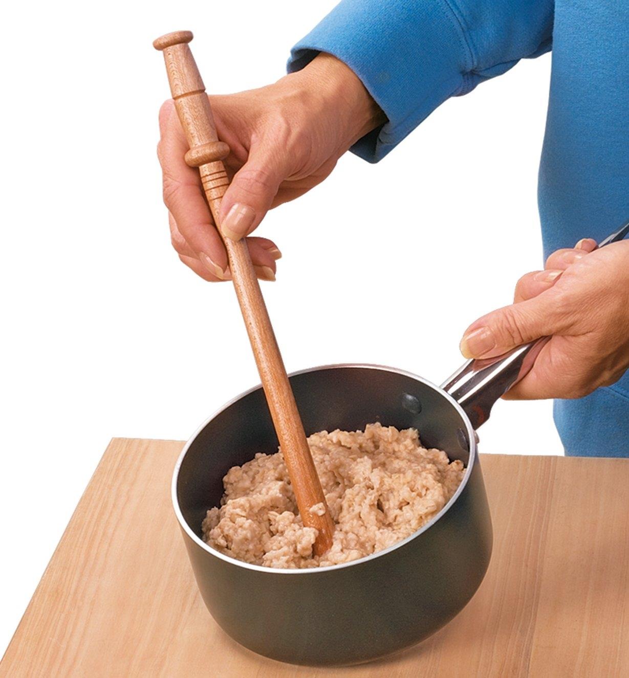 Mixing oatmeal in a pot with a Spurtle