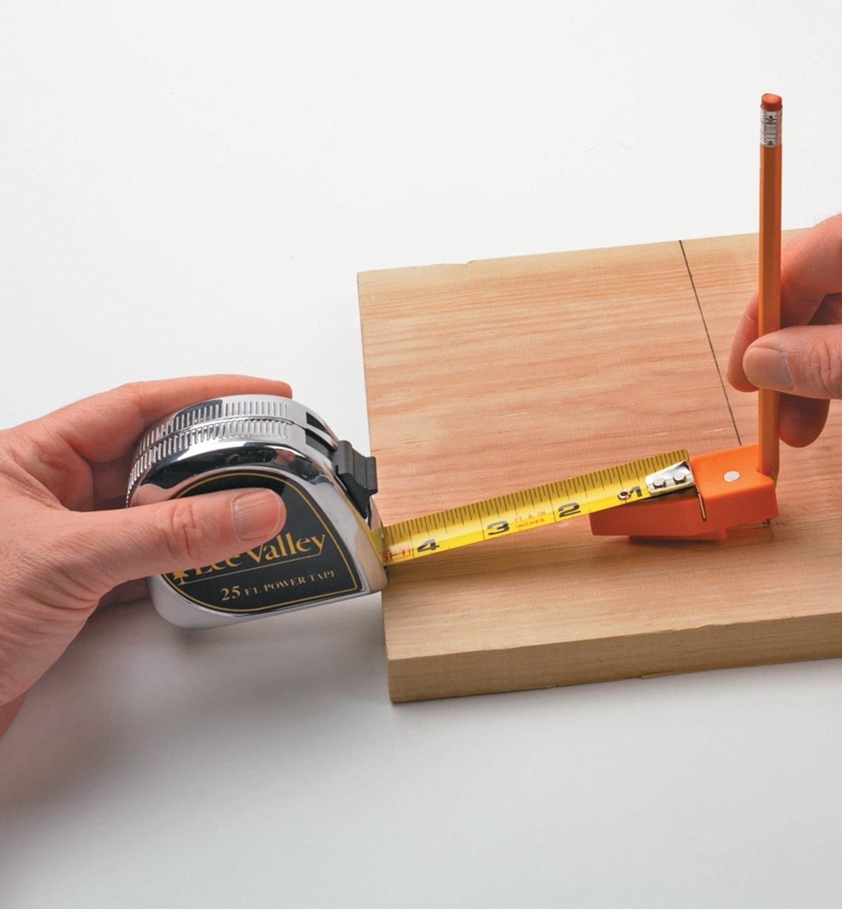 Marking a line across a board using a tape measure and tape tip