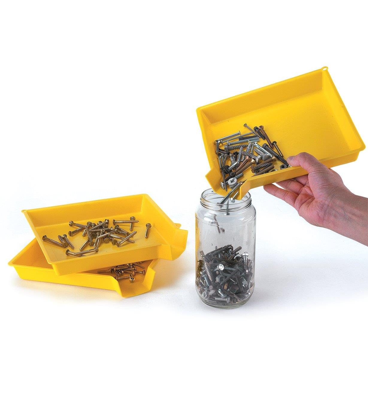 Pouring screws from a sorting tray into a jar