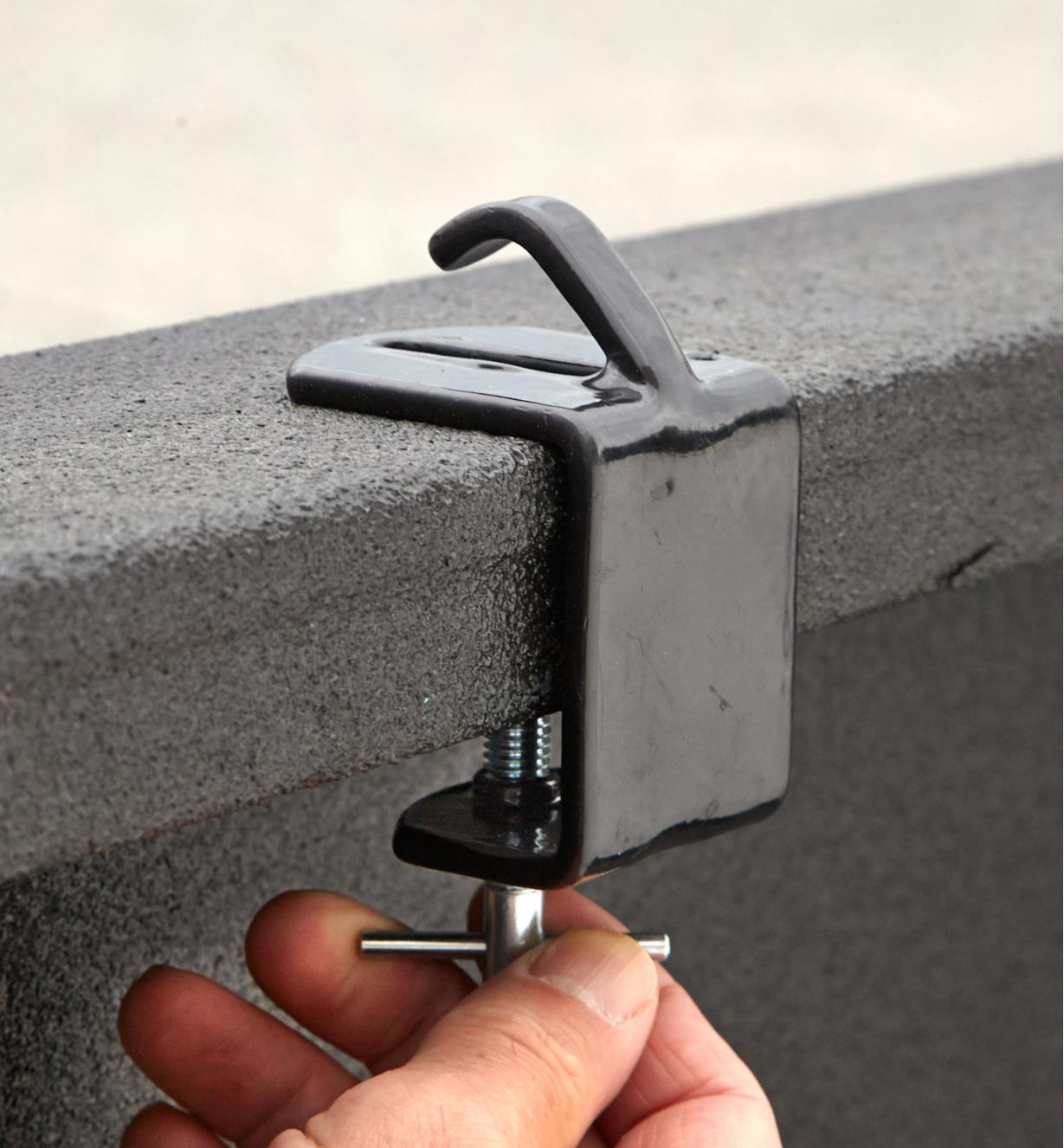 Tightening the clamping screw on a tie-down anchor to secure it to a truck rail