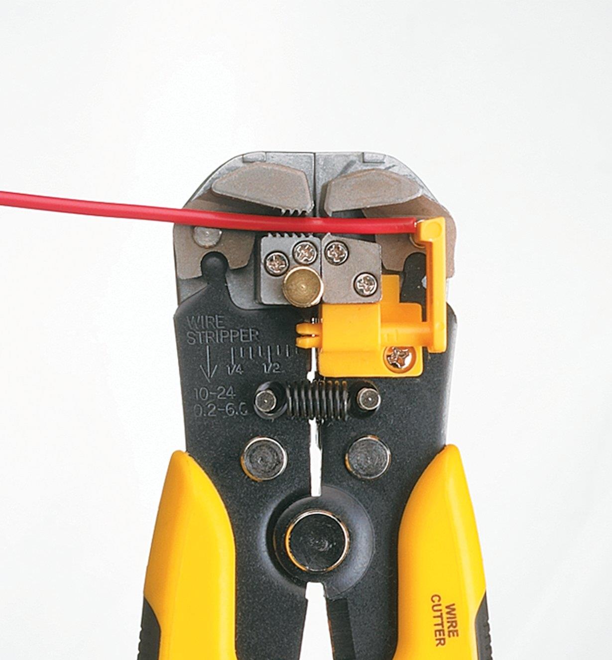 Close-up of wire stripper cutting jaw engaging the wire sheathing
