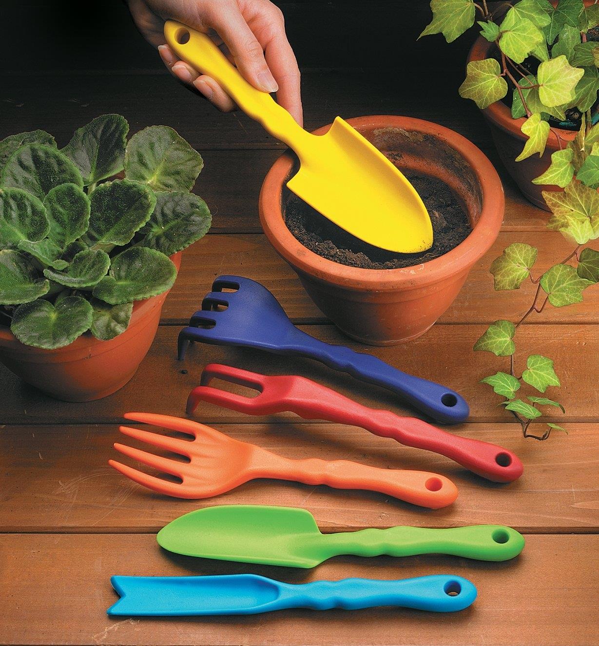 Adulte utilisant de petits outils de jardinage pour ses plantes en pot