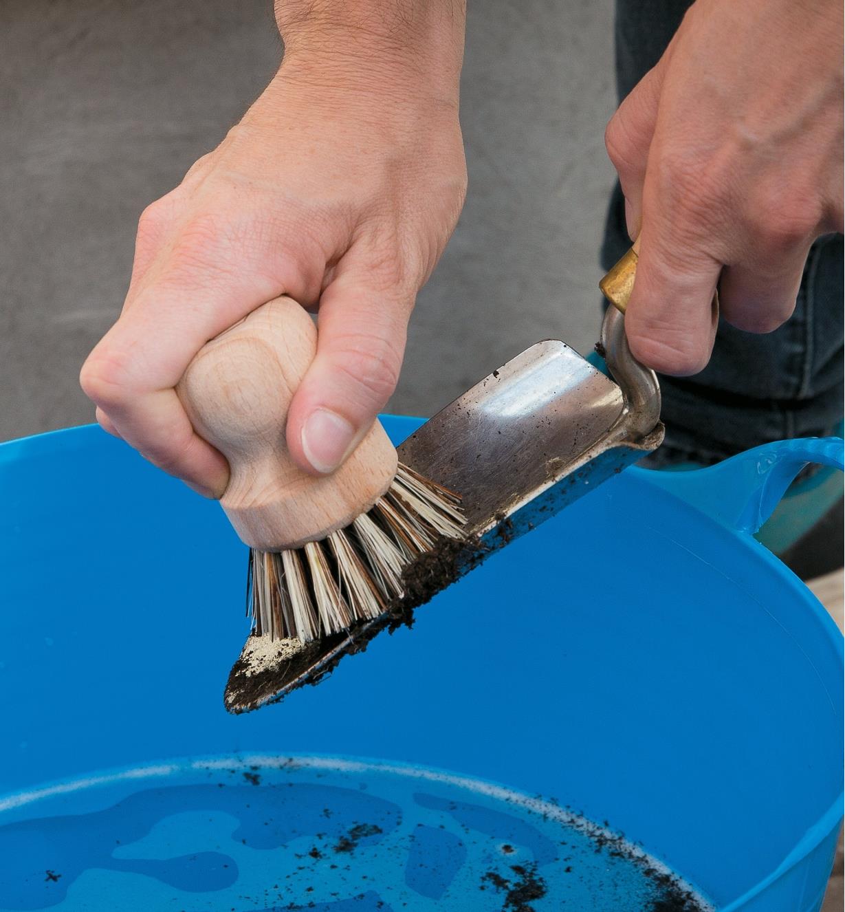 Using the scouring brush to clean a trowel